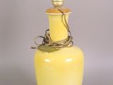 a yellow vase with a light bulb on top of it