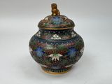 a vase with a lid that has flowers and birds on it