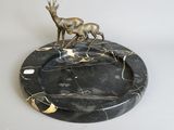 statue of a deer on a marble plate on a white surface