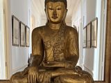 a gold buddha statue sitting in a hallway next to a mirror