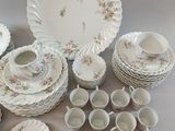 a lot of white dishes and cups on the table