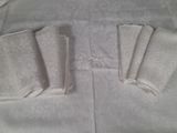 quatre serviettes pliées posées sur une nappe blanche
