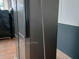 a black refrigerator sitting on a pallet in a warehouse