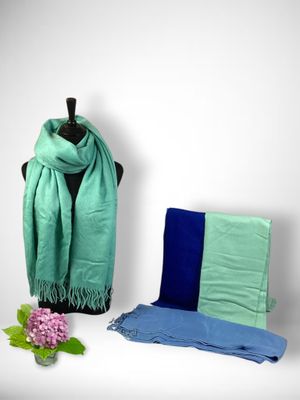 a green scarf and blue scarf on a mannequin stand