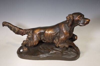 bronze statue of a dog on a rock on a white background