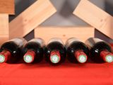 several bottles of wine are lined up on a red cloth