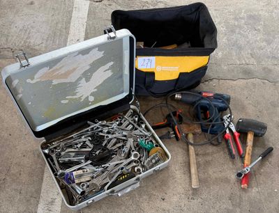 une trousse à outils posée par terre à côté d'un sac à outils