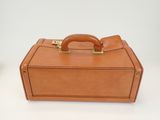 brown leather suitcase with handle on a white surface