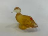 a small glass duck that is sitting on a table