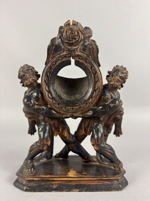 une petite horloge en bronze sur laquelle figurent un homme et une femme