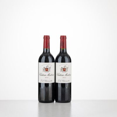 two bottles of red wine sitting on top of a table