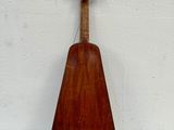 an old wooden instrument sitting on top of a white table