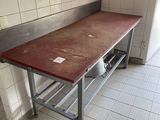 un plan de travail rouge dans une cuisine dont le mur est recouvert de carrelage blanc
