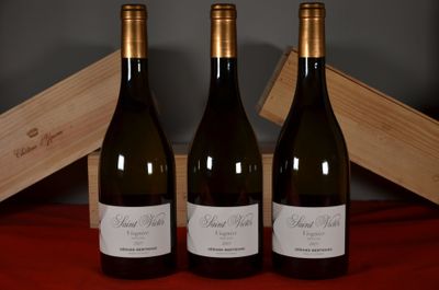 three bottles of wine sitting next to a wooden box on a table