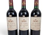 three bottles of red wine sitting next to each other on a white surface