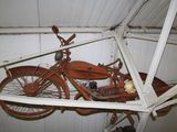 an old motorcycle hanging from the ceiling of a garage
