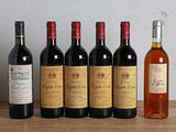 six bouteilles de vin sont alignées sur une table en bois