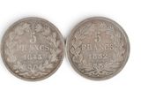a close up of two silver coins on a white surface