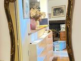 a mirror hanging on the wall next to a dresser