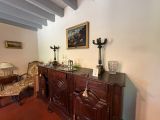 a room with a table, chairs, and a painting on the wall