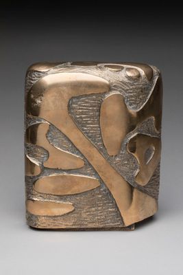 a close up of a metal object with leaves on it