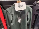 trois vestes suspendues à un portant dans un magasin