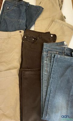 cinq paires de jeans étalées sur un lit