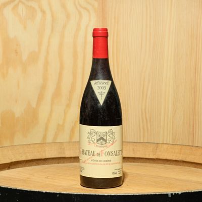 une bouteille de vin posée sur un tonneau en bois