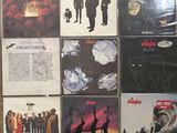 many different album covers on the wall of a room