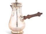 une cafetière ancienne en argent avec une poignée en bois sur fond blanc