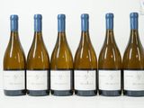 six bouteilles de vin sont alignées sur une surface blanche