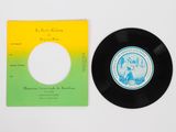 a black record with a yellow and green label next to a yellow and green record