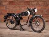 a black and white motorcycle parked in front of a brick wall