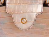 a close up of a white purse with a gold buckle