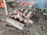 une machine qui est à l'abandon dans la poussière, près d'un bâtiment