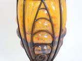 a yellow vase that is sitting on top of a stand