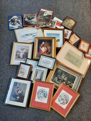 a pile of framed pictures on the floor of a living room