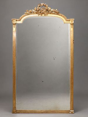 un grand miroir à cadre doré au motif ouvragé