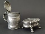 a silver cup and a silver plate on a table