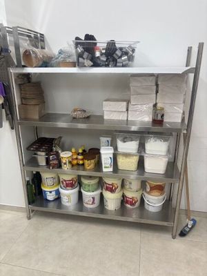 une étagère métallique sur laquelle sont posés des seaux remplis de nourriture