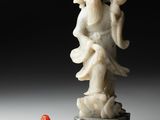 une image représentant une statue d'un homme tenant un objet rouge