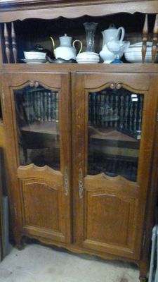 un meuble en bois avec une porte en verre dans une pièce