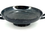 a black bowl with handles on a white surface