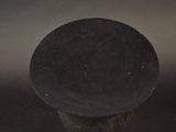 a black hat that is on top of a wooden pole