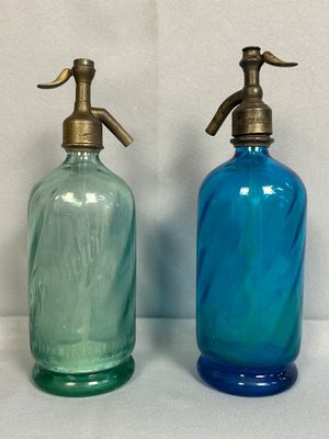 deux bouteilles en verre bleues et vertes placées l'une à côté de l'autre