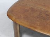a wooden table with a curved top on a white floor
