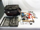 un sac d'outils posé sur une table à côté d'un autre sac d'outils