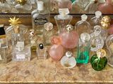 many bottles of perfume sitting on a counter in front of a mirror