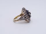 a close up of a gold and silver ring with a blue stone