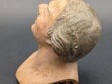 a clay head of a woman with a short hair